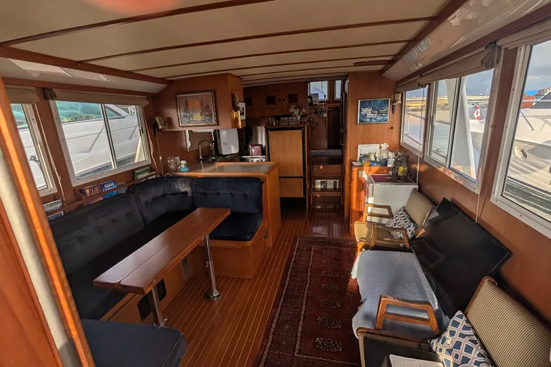 Moments Notice Yacht Photos Pics Interior of 1981 Sea Ranger 47 yacht with cozy seating and wooden decor.