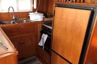 Moments Notice Yacht Photos Pics 1981 Sea Ranger 47 yacht kitchen with wooden cabinets, sink, and appliances.