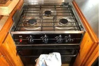 Moments Notice Yacht Photos Pics 1981 Sea Ranger 47 stove with three burners in a wooden kitchen setting.