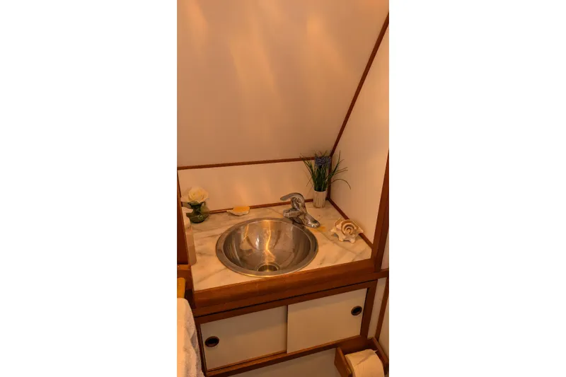 Moments Notice Yacht Photos Pics 1981 Sea Ranger 47 yacht bathroom with stainless steel sink and wooden accents.