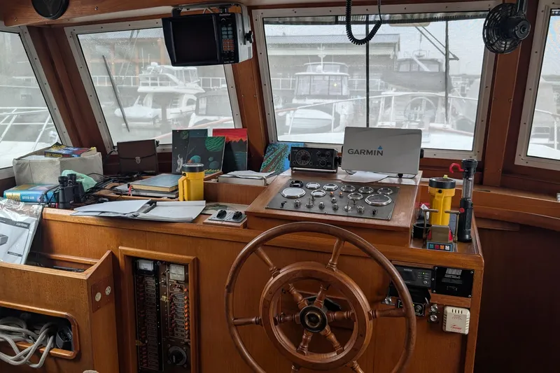 Moments Notice Yacht Photos Pics 1981 Sea Ranger 47 helm with wooden wheel, navigation instruments, and Garmin equipment.