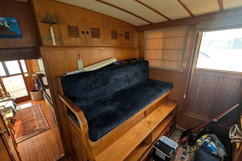 Moments Notice Yacht Photos Pics Interior of 1981 Sea Ranger 47 yacht with wooden paneling and blue cushioned seating.