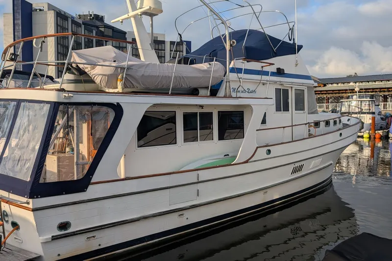Moments Notice Yacht Photos Pics 1981 Sea Ranger 47 yacht docked at marina, featuring classic design and spacious deck.