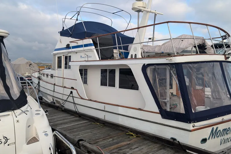 Moments Notice Yacht Photos Pics 1981 Sea Ranger 47 yacht docked at marina under cloudy sky.