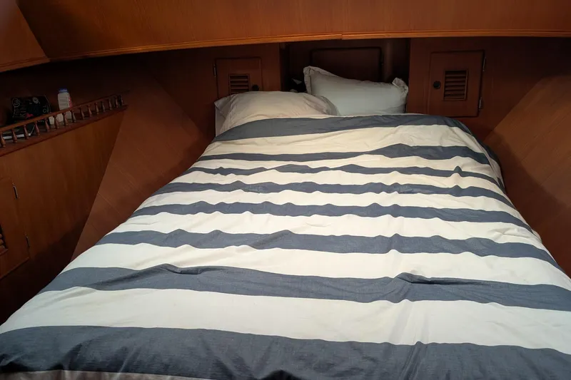 Moments Notice Yacht Photos Pics Cozy cabin bedroom in 1981 Sea Ranger 47 yacht with striped bedding.