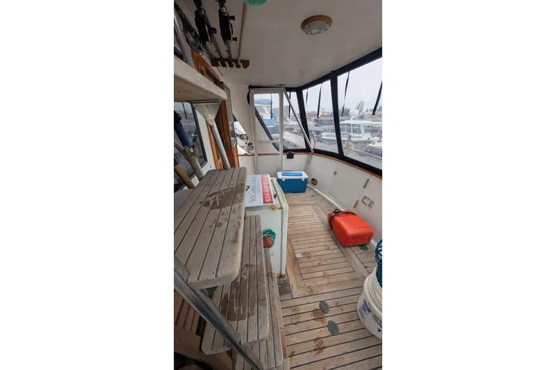 Moments Notice Yacht Photos Pics Interior view of 1981 Sea Ranger 47 boat with wooden flooring and fishing gear.