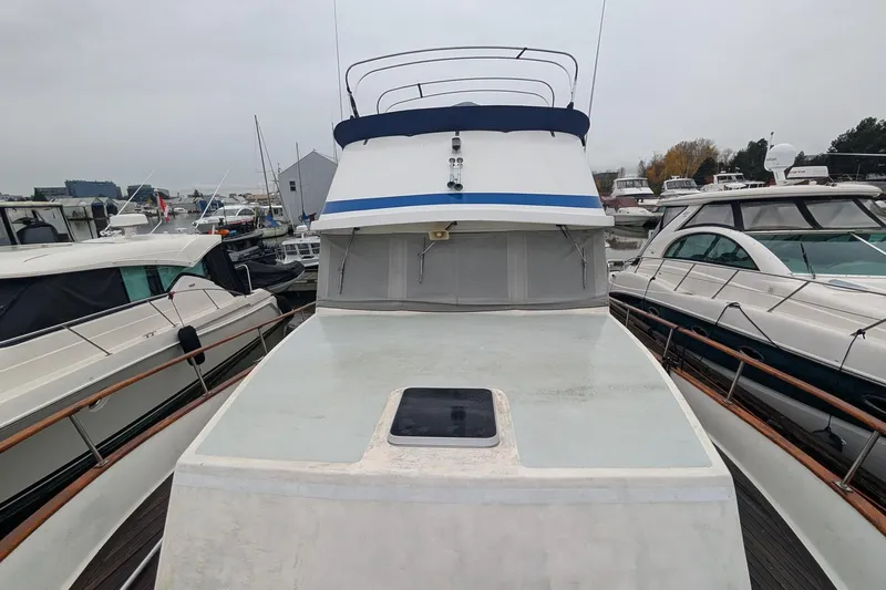 Moments Notice Yacht Photos Pics 1981 Sea Ranger 47 yacht docked among other boats in a marina.