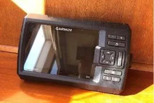 Moments Notice Yacht Photos Pics Garmin marine GPS device on Sea Ranger 47, 1981 model, wooden surface background.