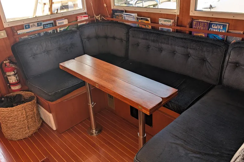 Moments Notice Yacht Photos Pics Cozy 1981 Sea Ranger 47 yacht interior with cushioned seating and wooden table.