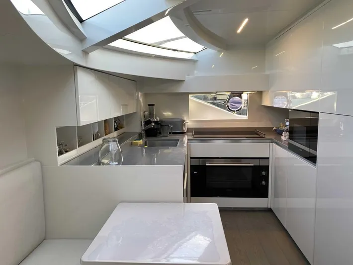  Yacht Photos Pics Modern kitchen interior of 2020 Ferretti Yachts 850, featuring sleek white cabinetry and appliances.