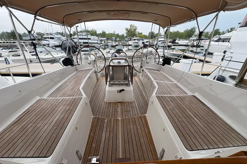 Star IV Yacht Photos Pics Cockpit of 2010 Jeanneau 50DS sailboat with wooden deck and dual steering wheels - Cushions removed