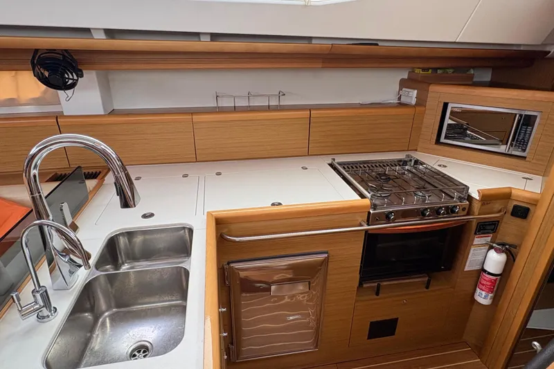 Star IV Yacht Photos Pics Modern kitchen in a 2010 Jeanneau 50DS yacht with stove, sink, and microwave.