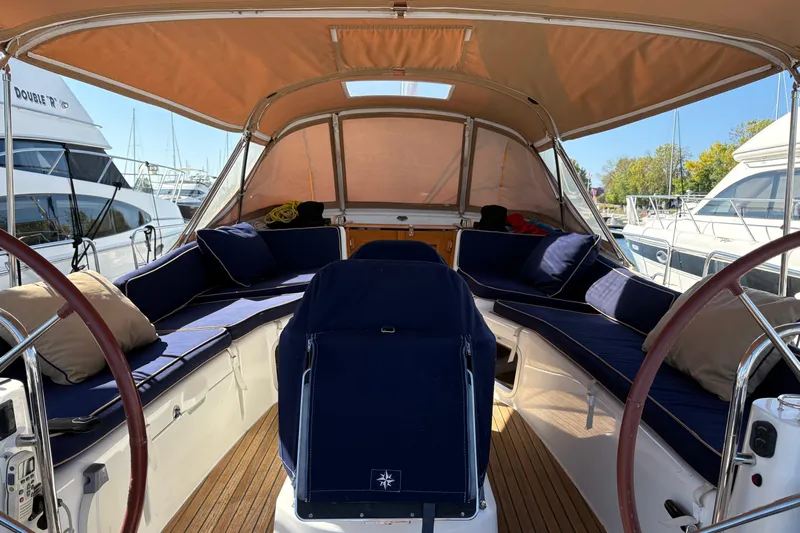 Star IV Yacht Photos Pics 2010 Jeanneau 50DS sailboat interior with blue seating and dual steering wheel and cockpit table cover.