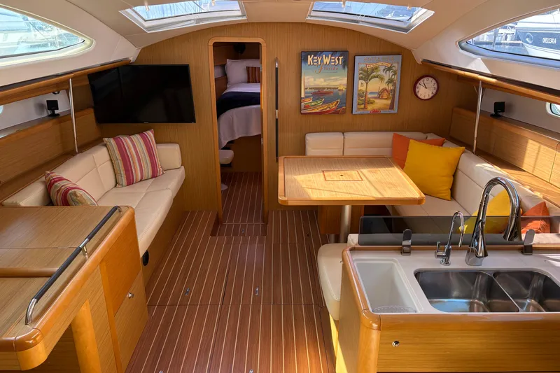 Star IV Yacht Photos Pics Luxurious interior of 2010 Jeanneau 50DS yacht with modern kitchen and cozy seating area.