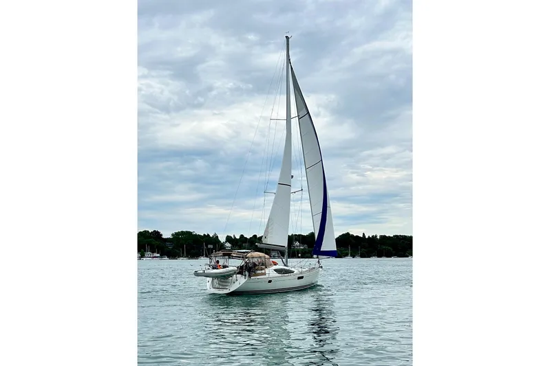 Star IV Yacht Photos Pics 2011 Jeanneau Sun Odyssey 50 DS sailing on calm waters under a cloudy sky.