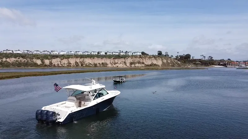 Lola Yacht Photos Pics 2017 Grady-White Freedom 375 boat on calm water with scenic shoreline background.