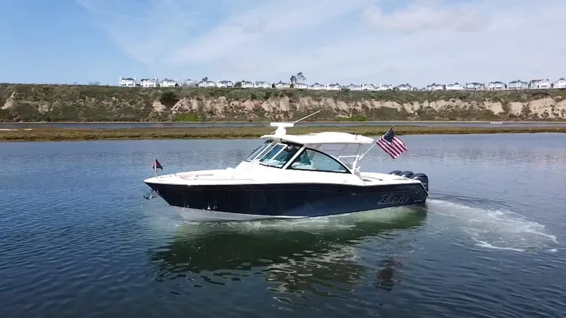 Lola Yacht Photos Pics 2017 Grady-White Freedom 375 boat cruising on calm water with American flag.
