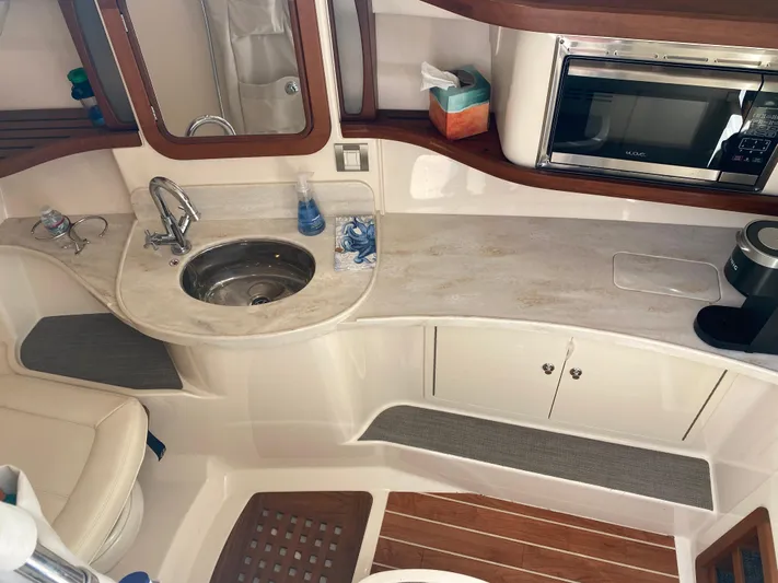 Lola Yacht Photos Pics 2017 Grady-White Freedom 375 boat interior with kitchenette, sink, and microwave.