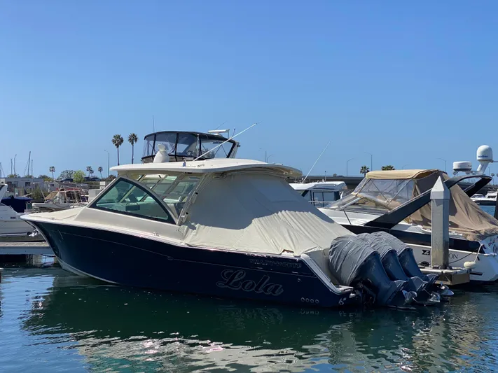 Lola Yacht Photos Pics 2017 Grady-White Freedom 375 boat docked in marina, clear sky, palm trees in background.