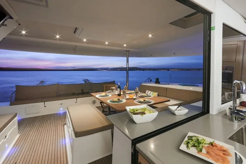 Nowhere Yacht Photos Pics Luxurious 2016 Fountaine Pajot SABA 50 yacht interior with elegant dining setup at sunset.