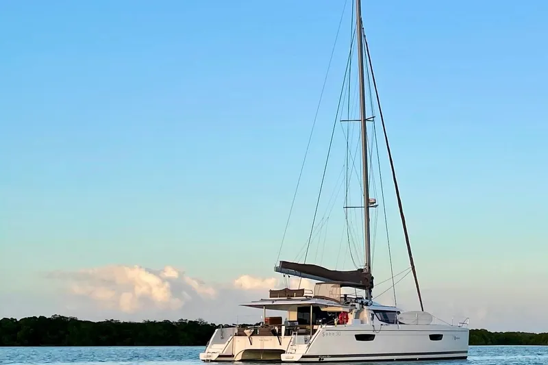 Nowhere Yacht Photos Pics 2016 Fountaine Pajot SABA 50 catamaran sailing on calm waters under a clear sky.