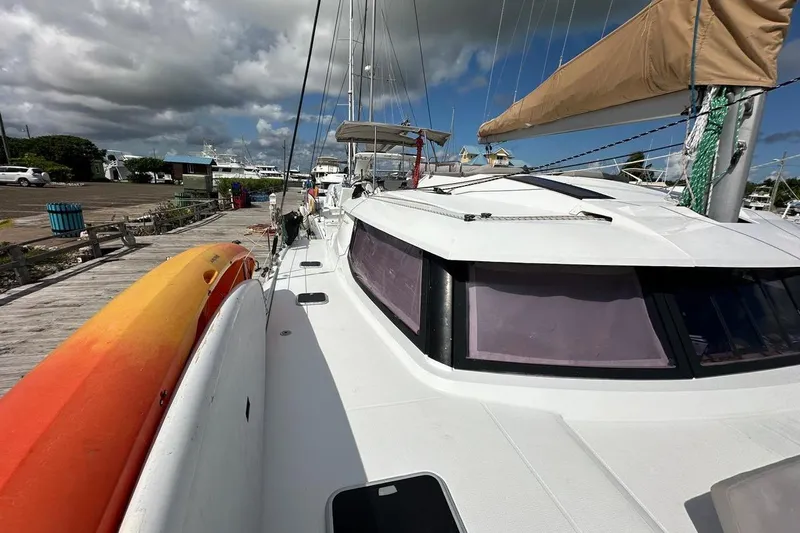 Nowhere Yacht Photos Pics 2016 Fountaine Pajot SABA 50 catamaran docked, featuring sleek design and vibrant kayak.