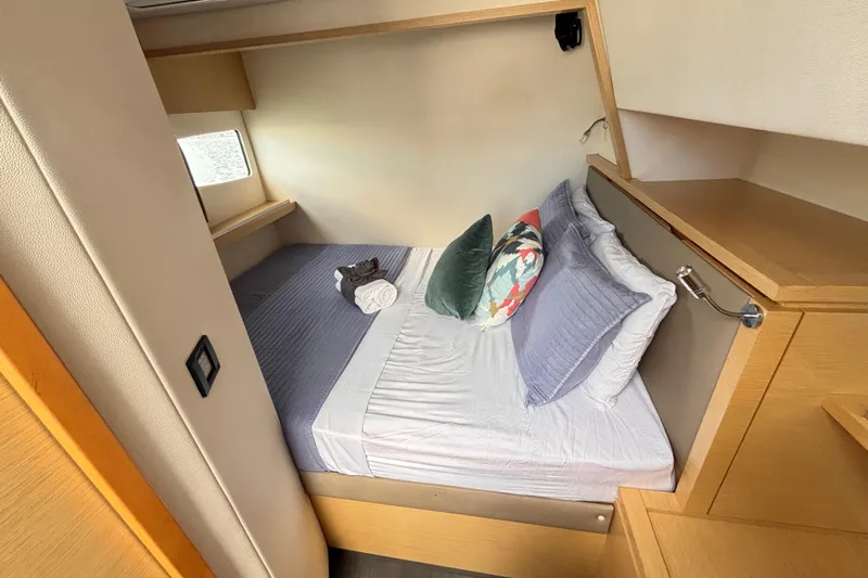 Nowhere Yacht Photos Pics Cozy cabin interior of 2016 Fountaine Pajot SABA 50 with neatly arranged bed and pillows.