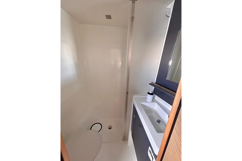 Nowhere Yacht Photos Pics Bathroom interior of 2016 Fountaine Pajot SABA 50 yacht, featuring modern sink and toilet.