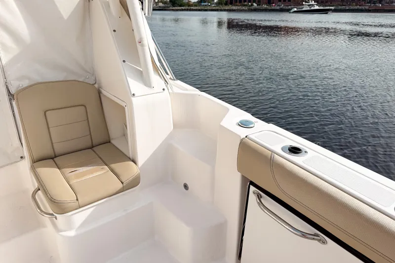  Yacht Photos Pics 2016 Pursuit OS 355 Offshore boat interior with beige seating by the water.