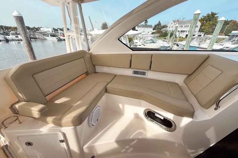  Yacht Photos Pics 2016 Pursuit OS 355 Offshore boat interior with beige seating, docked at marina.