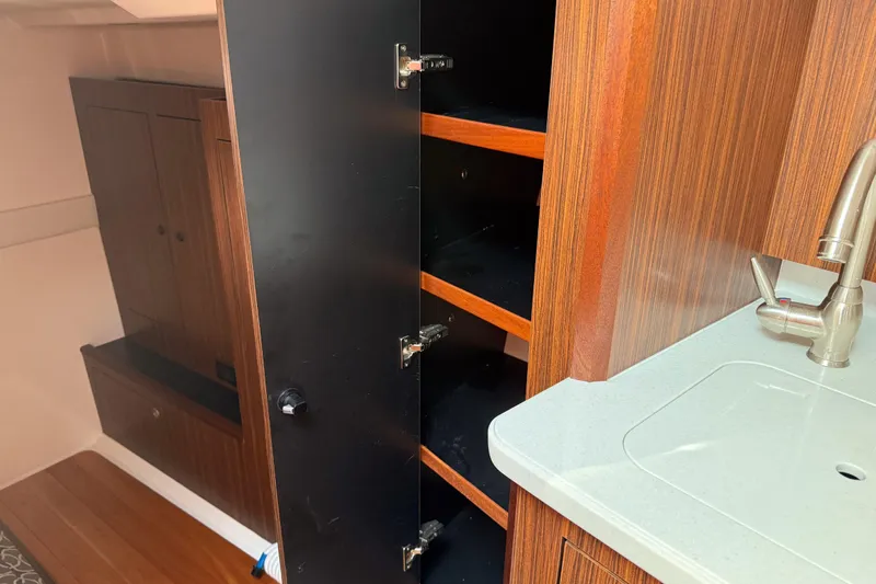  Yacht Photos Pics 2016 Pursuit OS 355 Offshore interior with open wooden cabinet and modern sink.