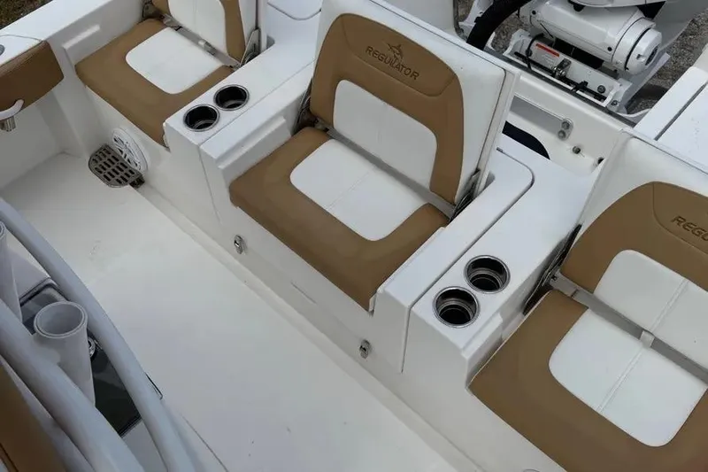  Yacht Photos Pics 2025 Regulator 26XO boat interior with tan and white seating, cup holders, and motor.