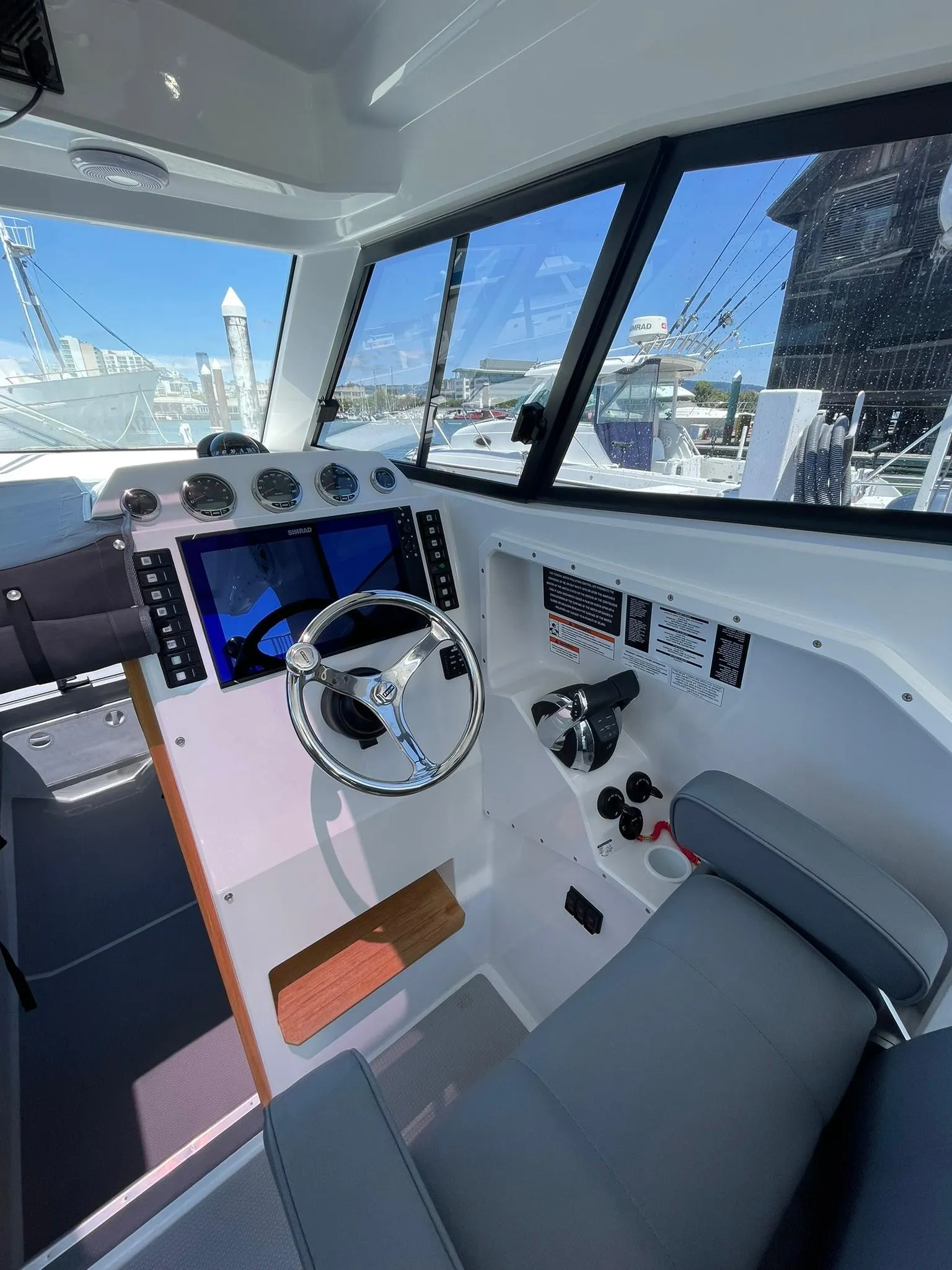 2024 Protector 310 Targa boat cockpit with steering wheel and navigation controls.