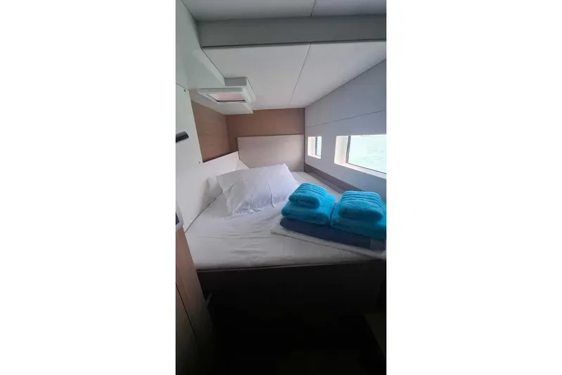 Zoie Yacht Photos Pics Cozy cabin interior of 2025 Bali CATSMART with bed and blue towels.