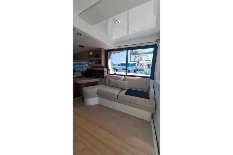 Zoie Yacht Photos Pics Interior of 2025 Bali CATSMART yacht with beige seating and large window view.