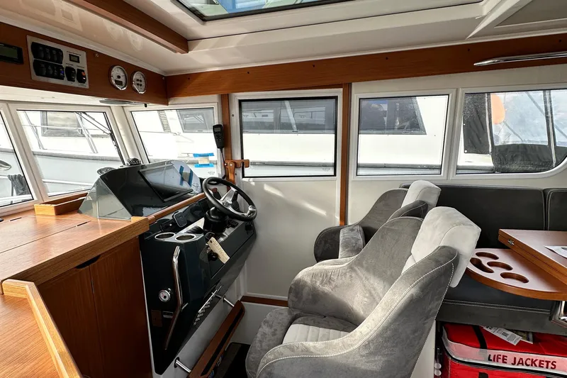  Yacht Photos Pics Interior of 2023 Sargo 28 boat with steering wheel and seating area.