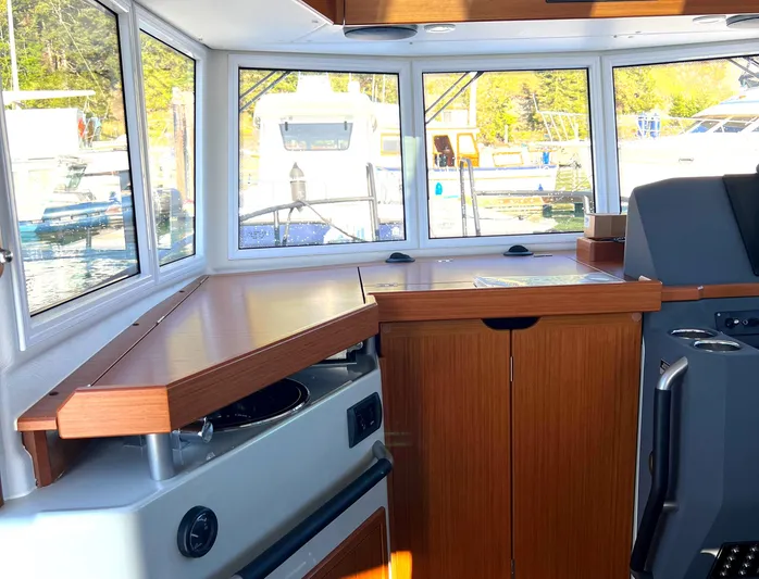  Yacht Photos Pics Interior of 2023 Sargo 28 boat with wooden cabinetry and large windows.