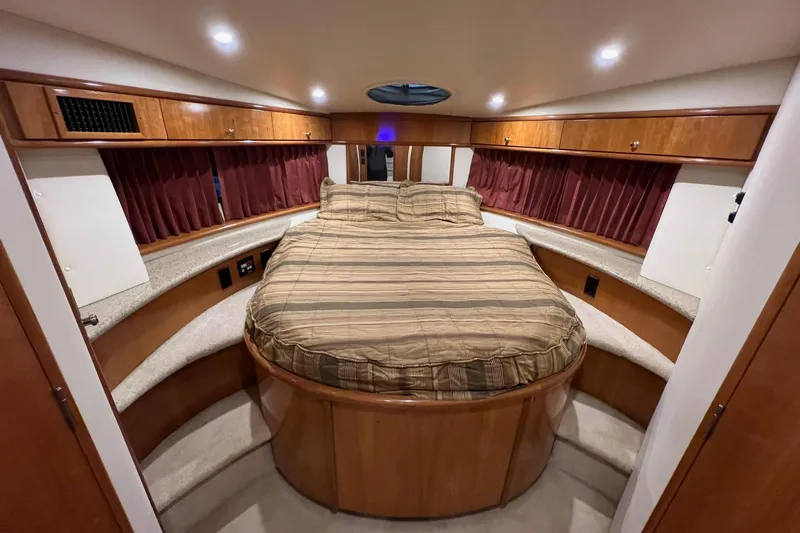  Yacht Photos Pics Luxurious bedroom interior of 2001 Carver 396 Motor Yacht with wood cabinetry and cozy bed.