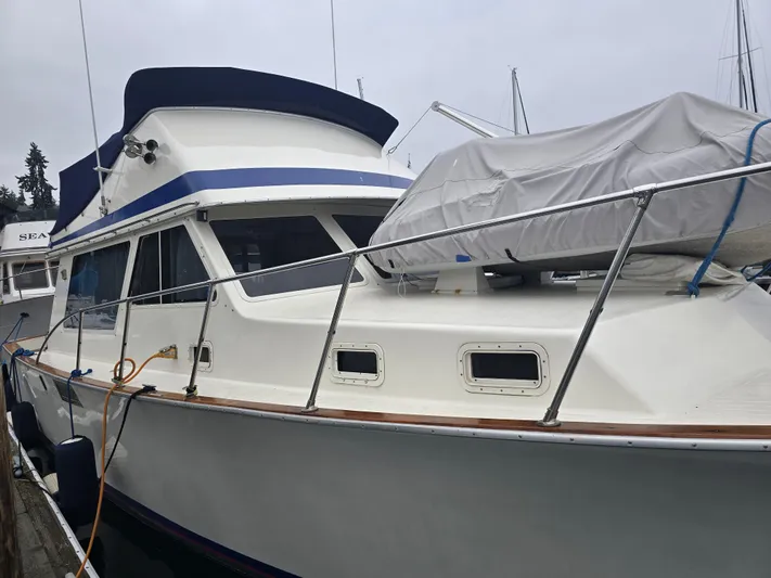 Aurora Yacht Photos Pics 1982 Tollycraft 37 Sportfish Convertible boat docked, featuring covered equipment on deck.