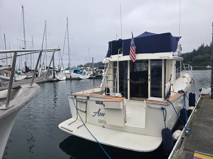 Aurora Yacht Photos Pics 1982 Tollycraft 37 Sportfish Convertible docked at a marina, featuring an American flag.