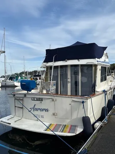 Aurora Yacht Photos Pics 1982 Tollycraft 37 Sportfish Convertible docked at marina, named "Aurora," with blue canopy.