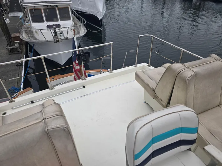 Aurora Yacht Photos Pics 1982 Tollycraft 37 Sportfish Convertible boat deck with seating, docked at marina.