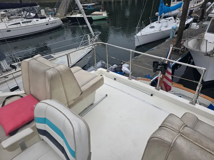 Aurora Yacht Photos Pics 1982 Tollycraft 37 Sportfish Convertible at marina, featuring spacious deck and seating.