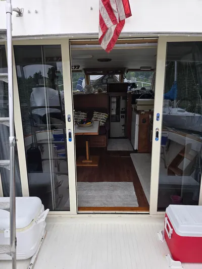 Aurora Yacht Photos Pics 1982 Tollycraft 37 Sportfish Convertible interior view with sliding doors and American flag.