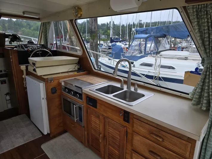 Aurora Yacht Photos Pics Interior of 1982 Tollycraft 37 Sportfish with kitchen and marina view.