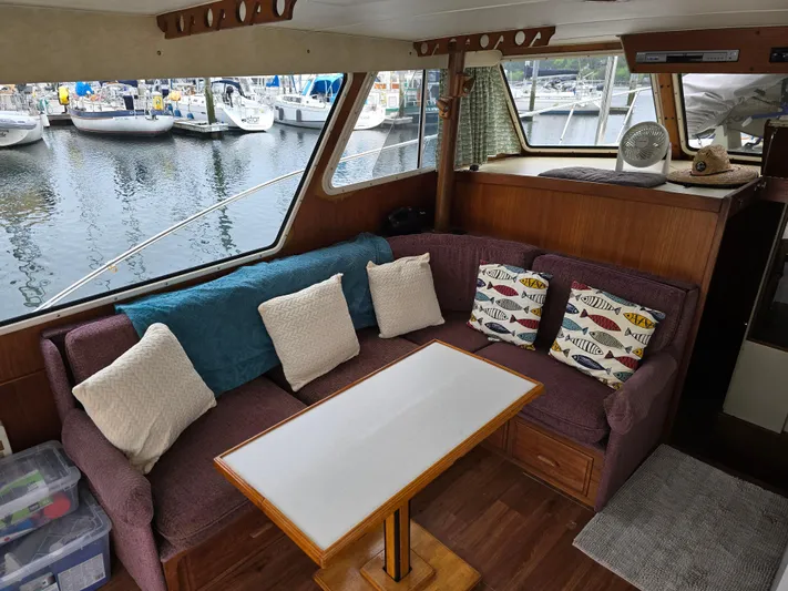 Aurora Yacht Photos Pics Interior of 1982 Tollycraft 37 Sportfish with cozy seating and marina view.