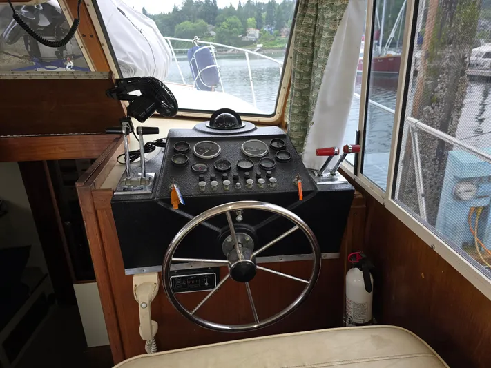 Aurora Yacht Photos Pics 1982 Tollycraft 37 Sportfish Convertible helm with steering wheel and control panel.