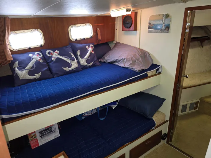 Aurora Yacht Photos Pics Cozy cabin interior of 1982 Tollycraft 37 Sportfish with nautical-themed bedding.