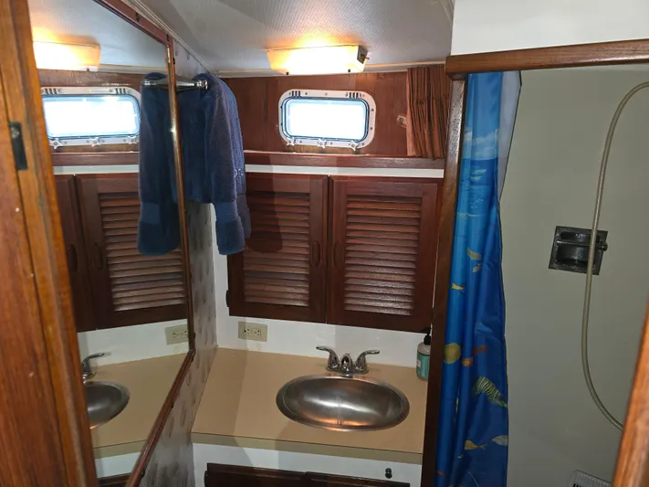 Aurora Yacht Photos Pics 1982 Tollycraft 37 Sportfish bathroom with sink, mirror, and shower curtain.