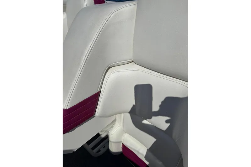 Grabbn Air Yacht Photos Pics White and maroon boat seat in 1997 Fountain 42 Lightning, with shadow of a hand.